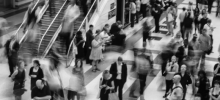 A crowd of commuters passing through a train station.